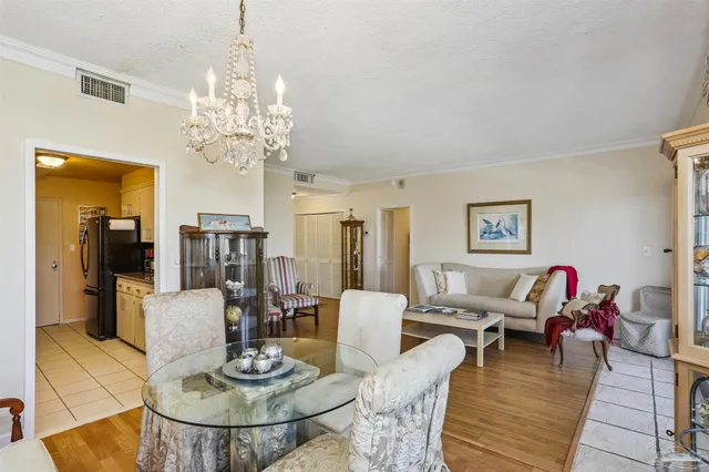 a view of a dining room with furniture a chandelier and wooden floor