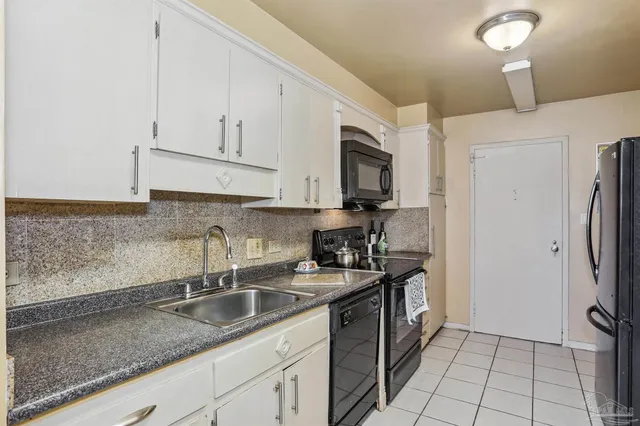a kitchen with stainless steel appliances granite countertop a sink a stove a refrigerator and a counter top