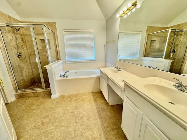 a bathroom with a tub sink and mirror