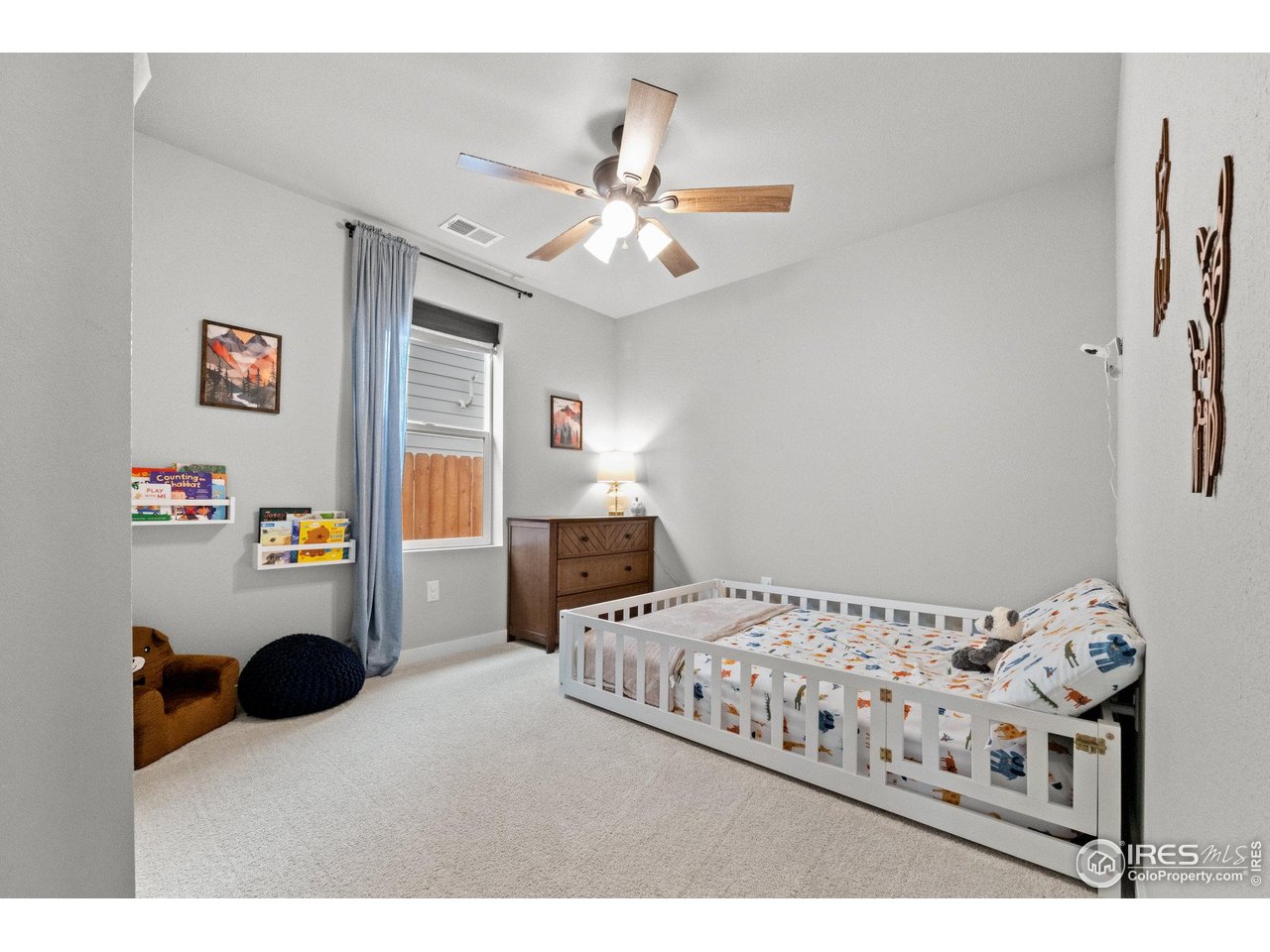 515 Wildcat Parkway Wiggins, CO 80654 - Photo 11 of 43 a bedroom with a bed and a chandelier