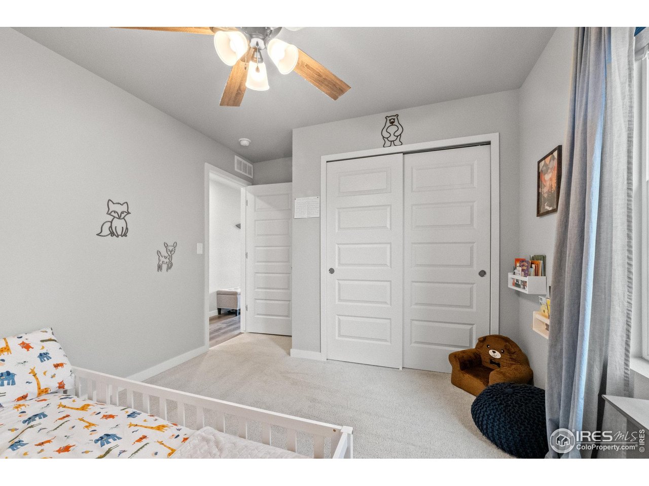 515 Wildcat Parkway Wiggins, CO 80654 - Photo 13 of 43 a bedroom with a bed and a chandelier fan