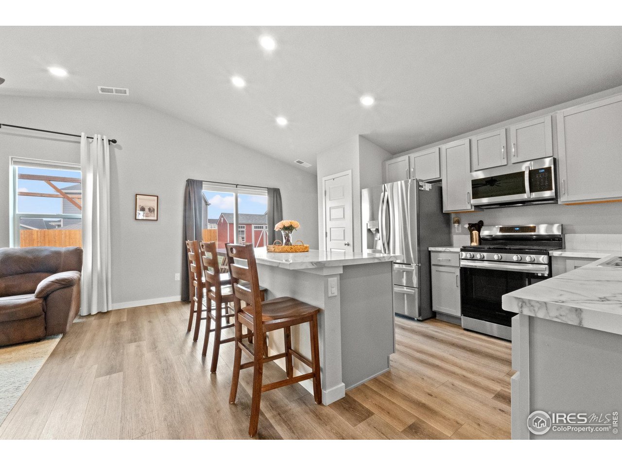 515 Wildcat Parkway Wiggins, CO 80654 - Photo 16 of 43 a kitchen with a table chairs refrigerator and microwave