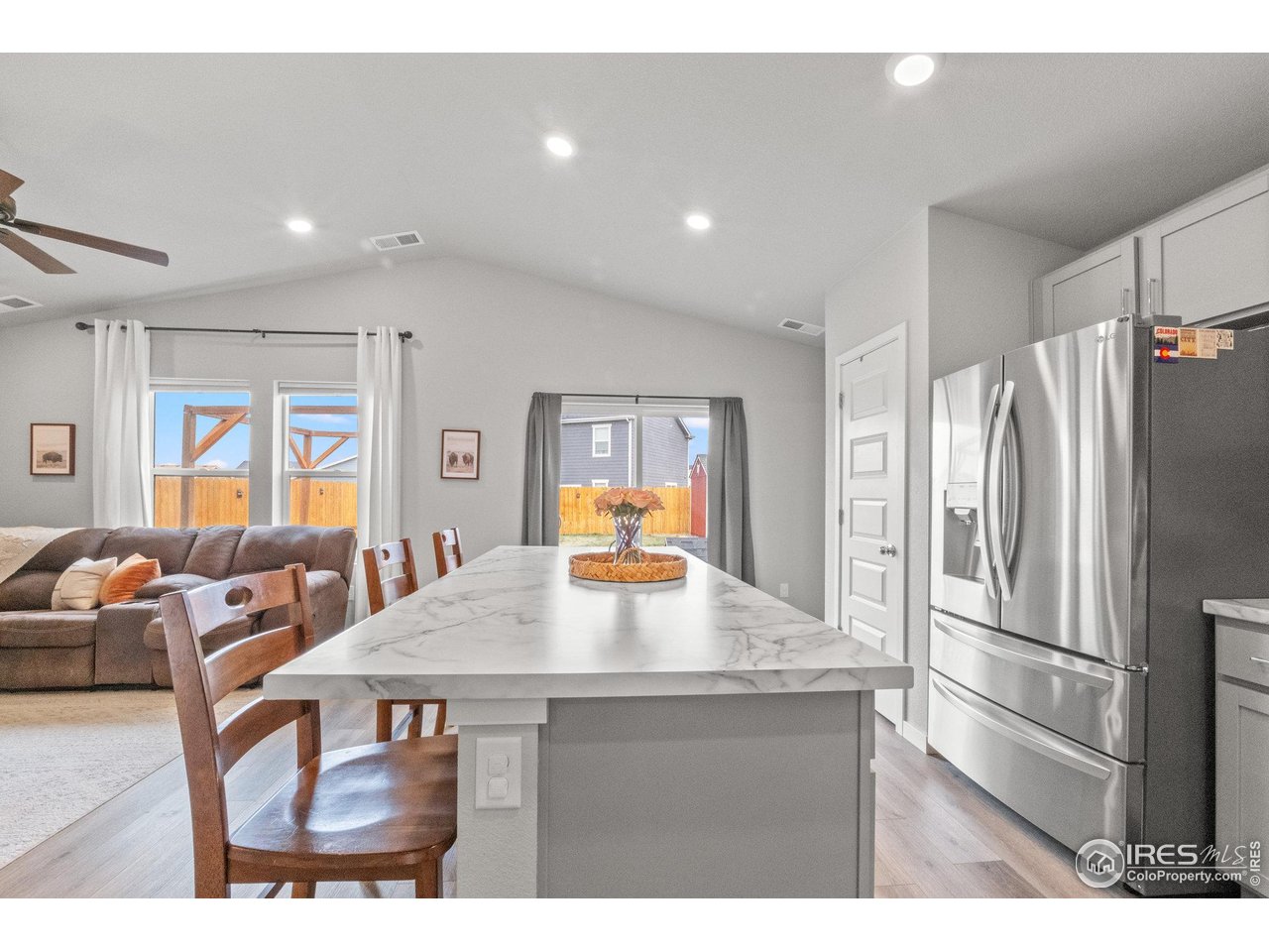 515 Wildcat Parkway Wiggins, CO 80654 - Photo 17 of 43 a kitchen with stainless steel appliances wooden floor dining table and chairs