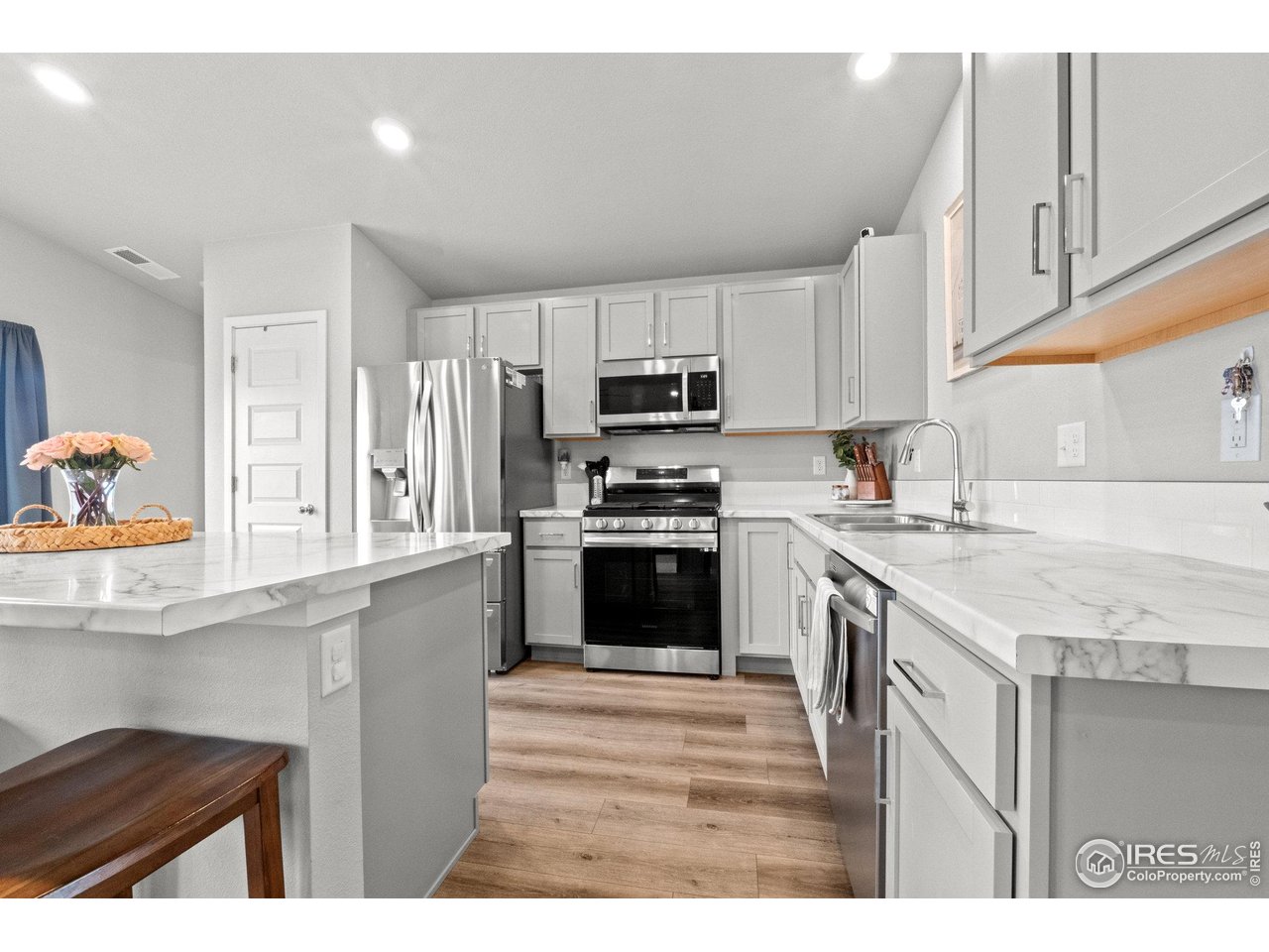 515 Wildcat Parkway Wiggins, CO 80654 - Photo 18 of 43 a kitchen with granite countertop a stove a sink and a microwave