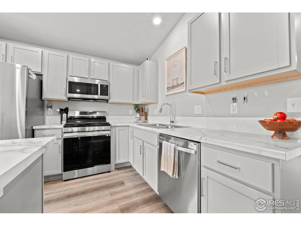 515 Wildcat Parkway Wiggins, CO 80654 - Photo 19 of 43 a kitchen with granite countertop white cabinets and stainless steel appliances