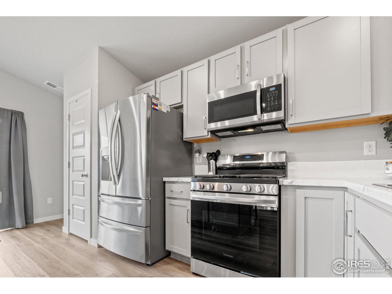 515 Wildcat Parkway Wiggins, CO 80654 - Photo 20 of 43 a kitchen with stainless steel appliances a stove a microwave and a refrigerator