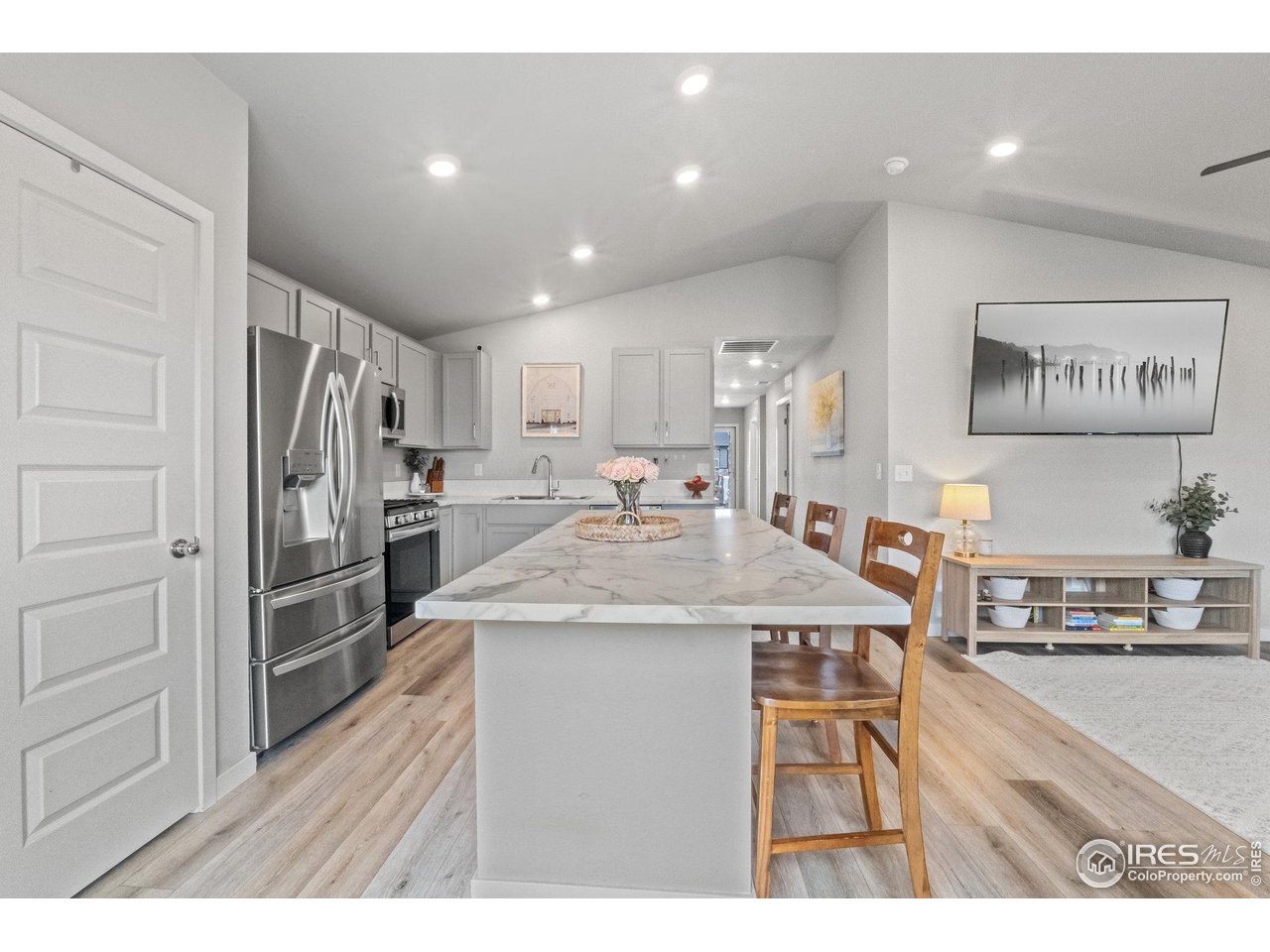 515 Wildcat Parkway Wiggins, CO 80654 - Photo 21 of 43 a kitchen with stainless steel appliances kitchen island granite countertop a refrigerator and a stove top oven