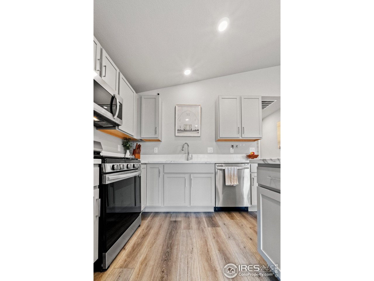 515 Wildcat Parkway Wiggins, CO 80654 - Photo 24 of 43 a kitchen with a sink stove and cabinets