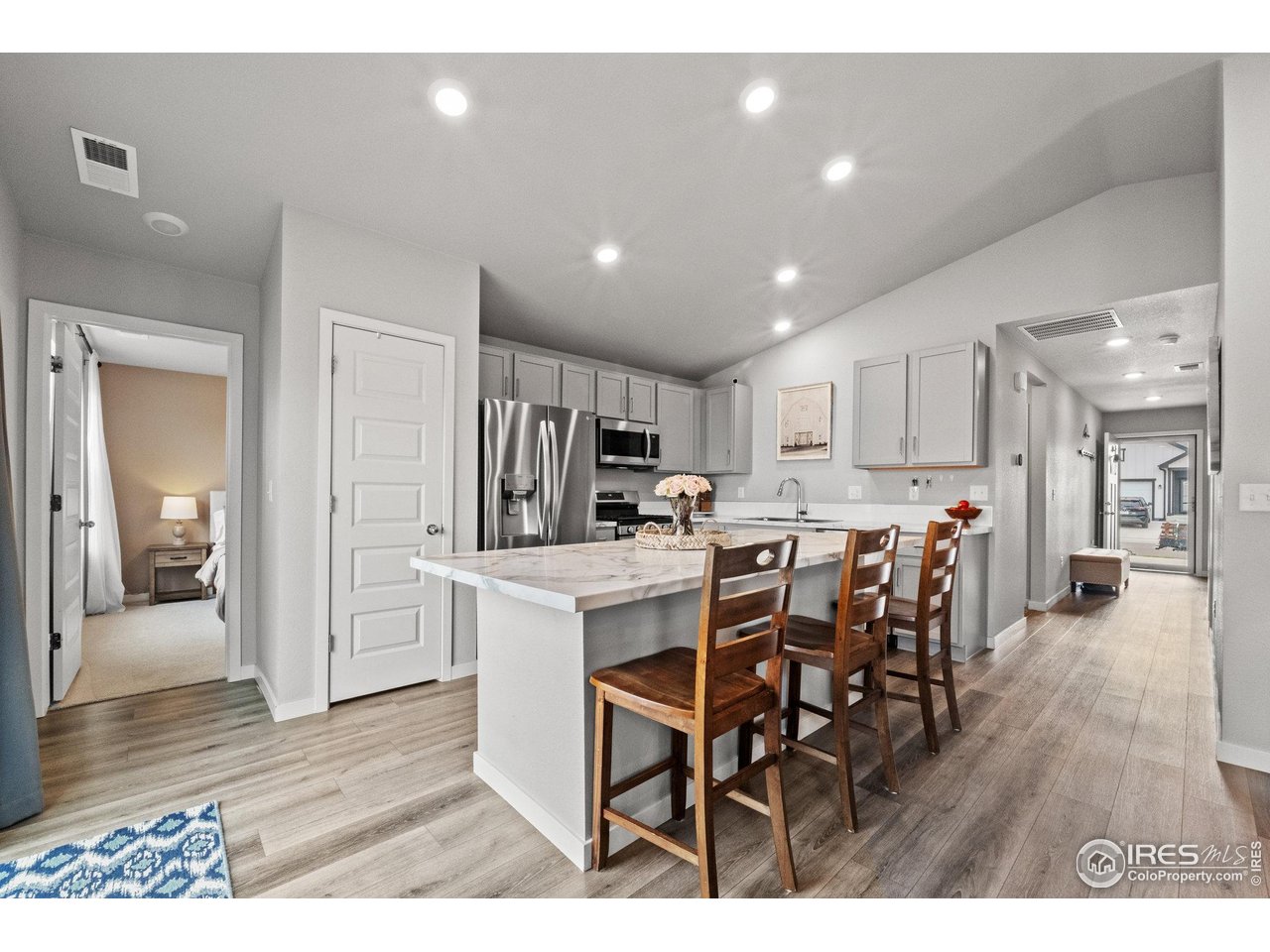 515 Wildcat Parkway Wiggins, CO 80654 - Photo 25 of 43 a kitchen with stainless steel appliances kitchen island granite countertop a dining table chairs and granite counter tops