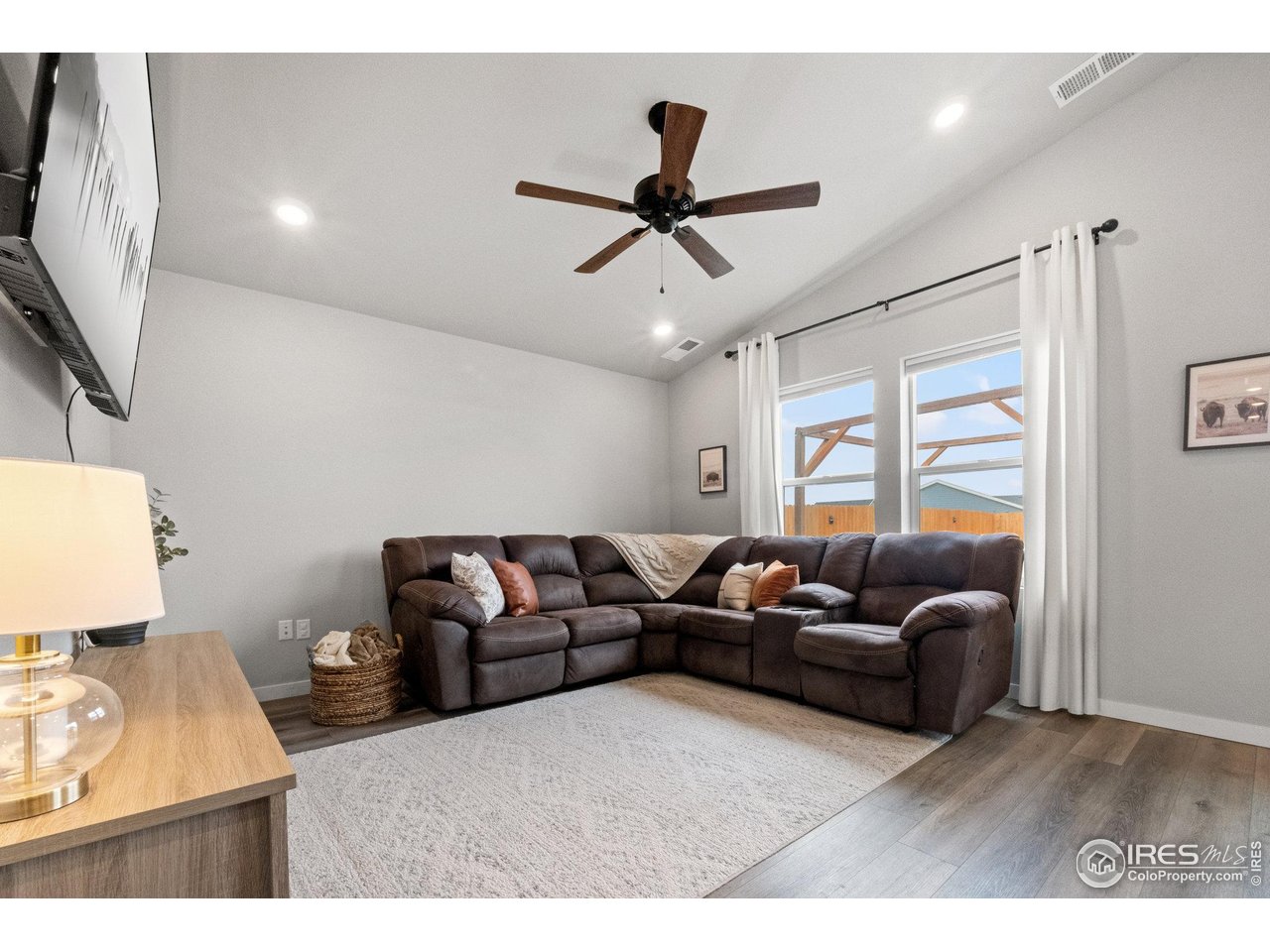 515 Wildcat Parkway Wiggins, CO 80654 - Photo 27 of 43 a living room with furniture and a flat screen tv