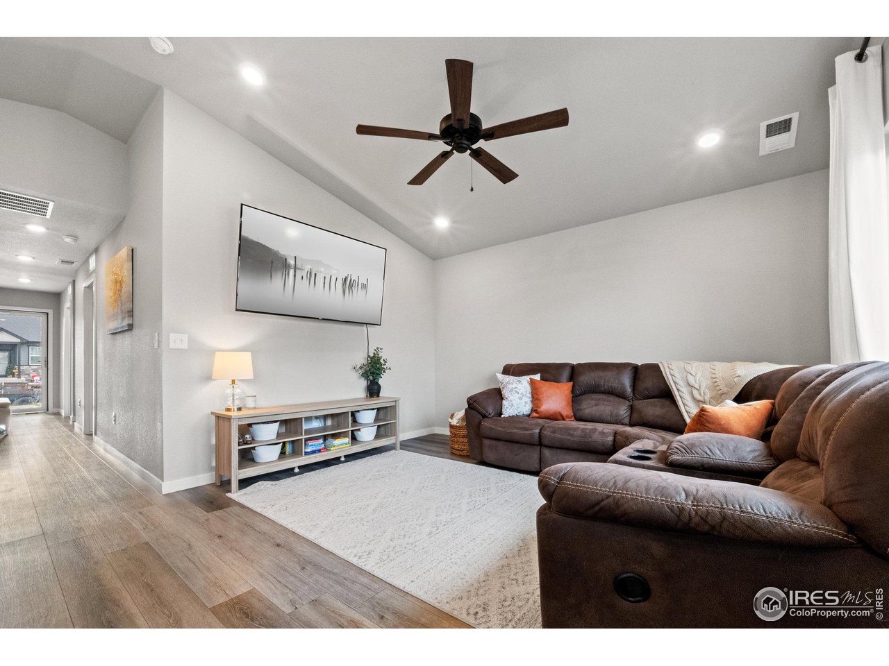 515 Wildcat Parkway Wiggins, CO 80654 - Photo 28 of 43 a living room with furniture and a wooden floor