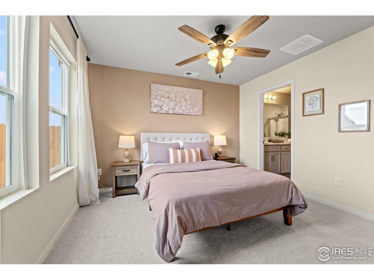 515 Wildcat Parkway Wiggins, CO 80654 - Photo 30 of 43 a bedroom with a bed and a chandelier