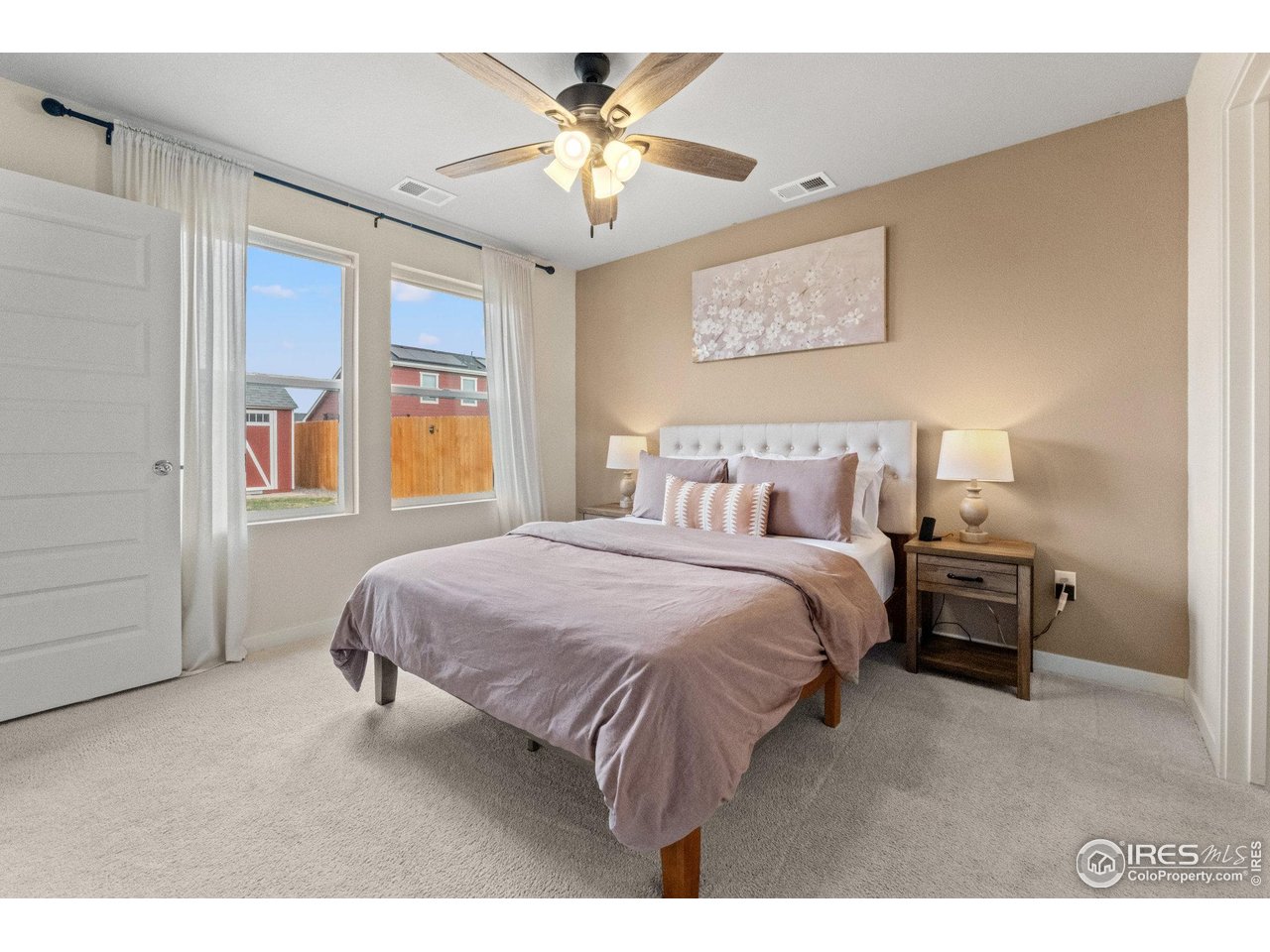 515 Wildcat Parkway Wiggins, CO 80654 - Photo 31 of 43 a spacious bedroom with a bed a dresser and a chandelier