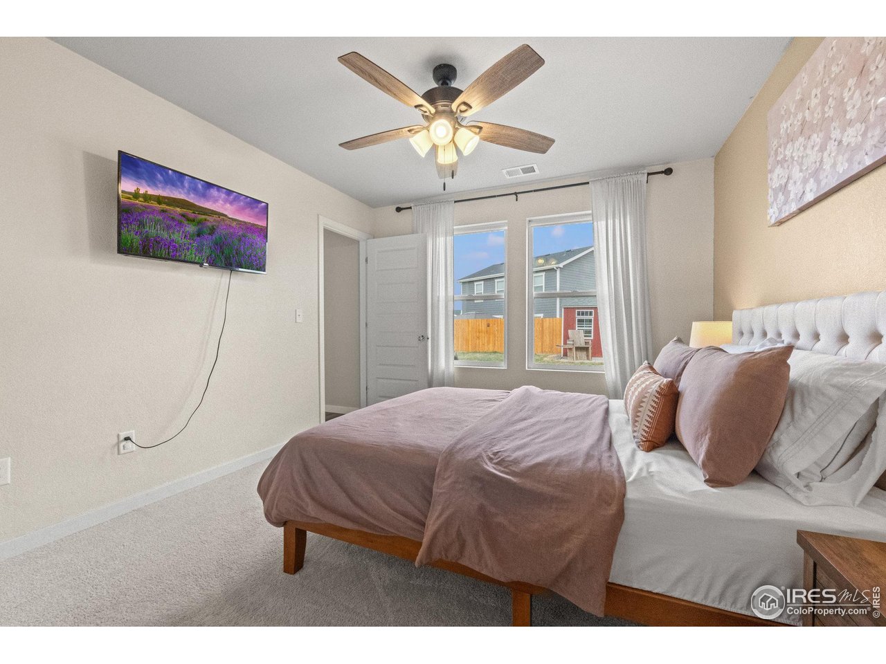 515 Wildcat Parkway Wiggins, CO 80654 - Photo 32 of 43 a bedroom with a bed and a chandelier