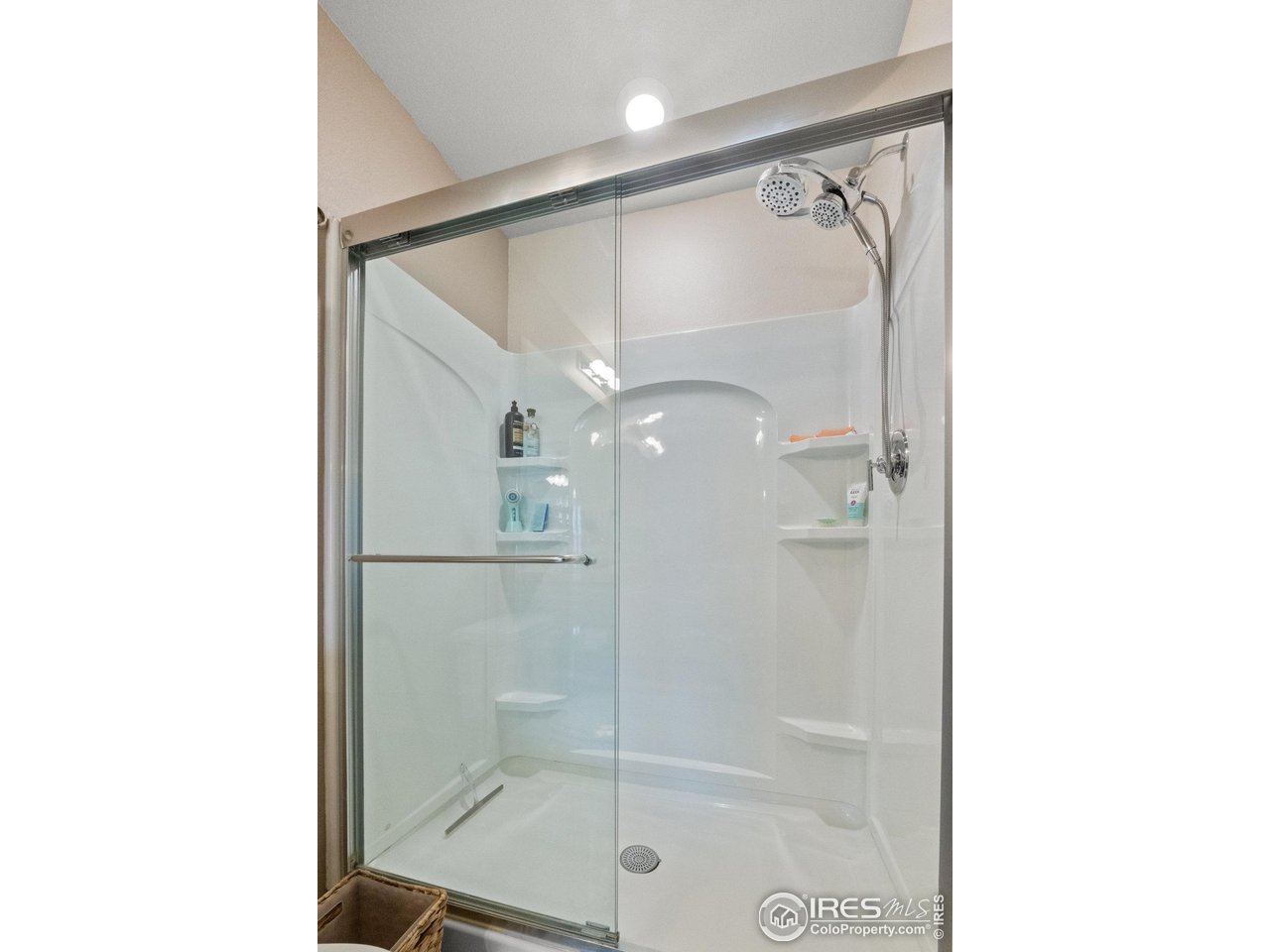 515 Wildcat Parkway Wiggins, CO 80654 - Photo 36 of 43 a bathroom with a glass shower door