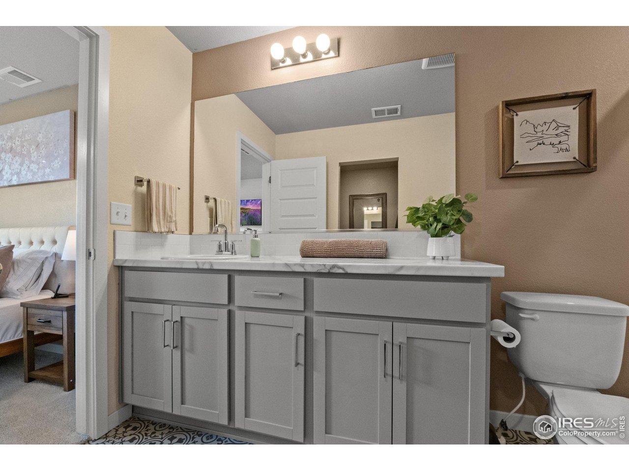 515 Wildcat Parkway Wiggins, CO 80654 - Photo 38 of 43 a bathroom with a granite countertop sink a toilet and a mirror