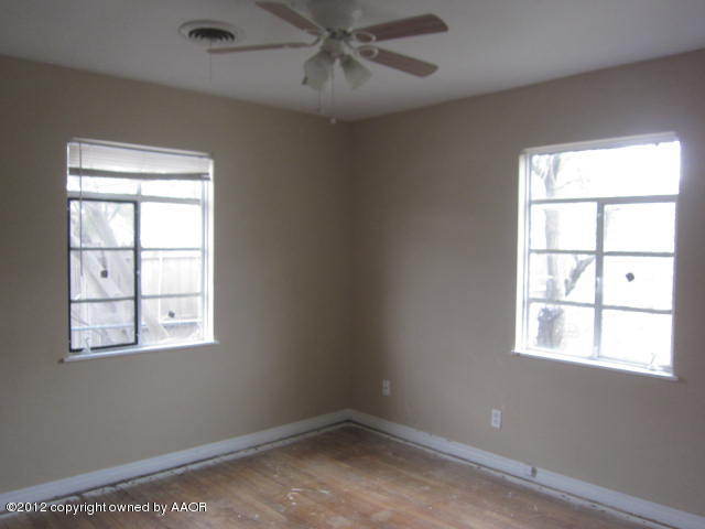 4618 Cline Road Amarillo, TX 79110 - Photo 8 of 10 an empty room with a window and ceiling fan