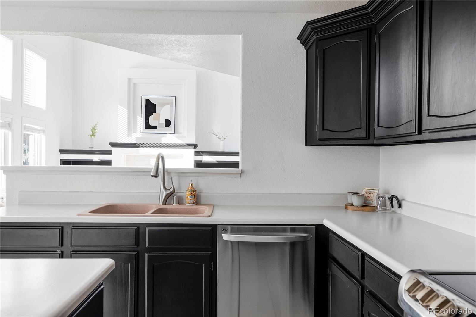 12829 Claude Place Thornton, CO 80241 - Photo 11 of 39 a kitchen with a sink cabinets and a wooden floor