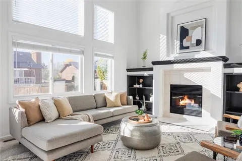a living room with furniture a fireplace and a large window