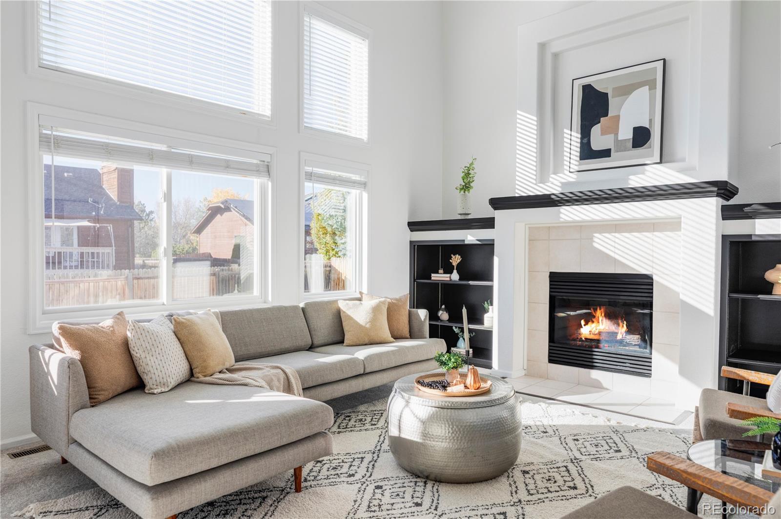 12829 Claude Place Thornton, CO 80241 - Photo 16 of 39 a living room with furniture a fireplace and a large window
