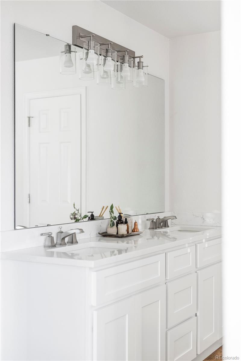 12829 Claude Place Thornton, CO 80241 - Photo 29 of 39 a bathroom with a sink and a mirror
