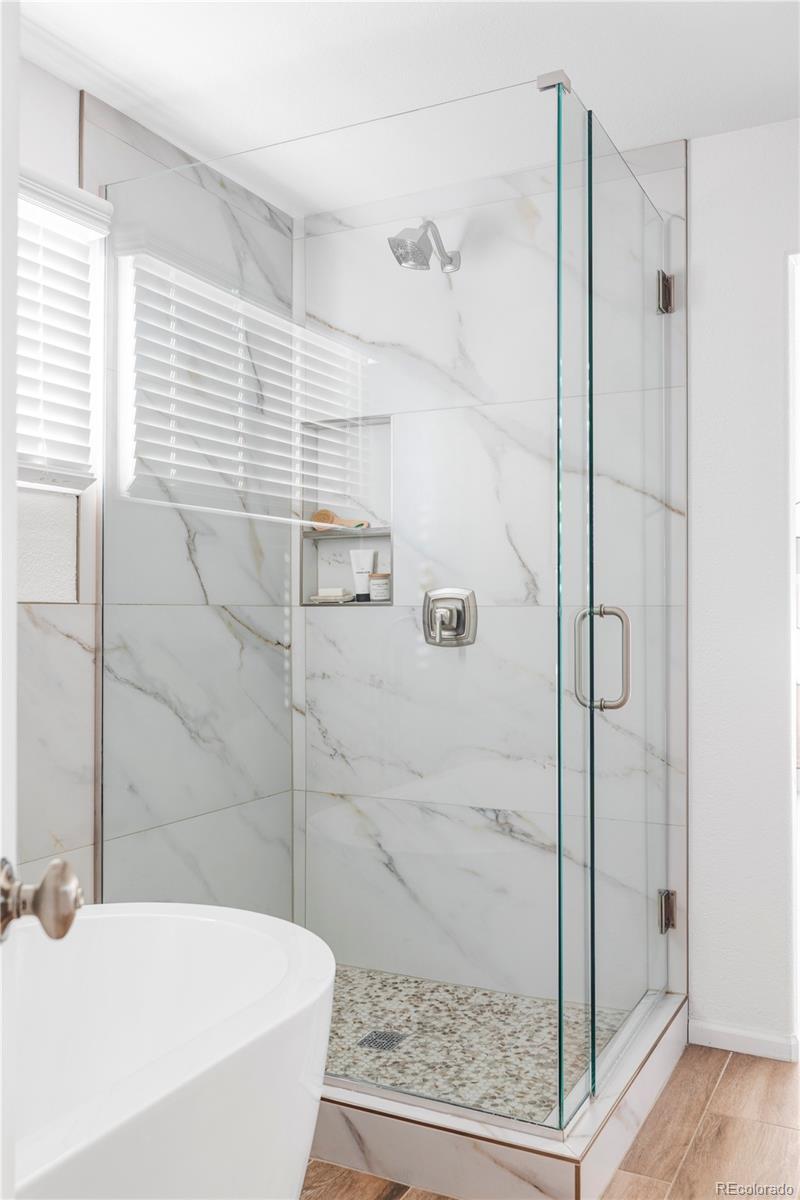 12829 Claude Place Thornton, CO 80241 - Photo 30 of 39 a bathroom with a bathtub and a shower