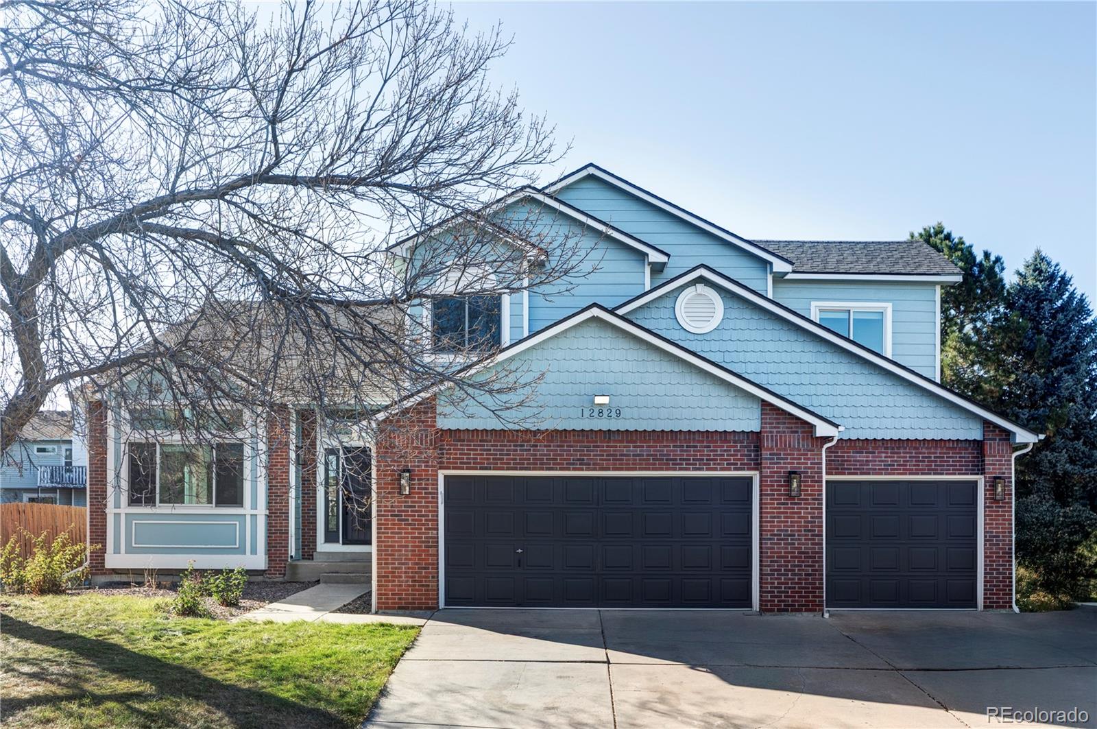 12829 Claude Place Thornton, CO 80241 - Photo 3 of 39 a front view of a house with a yard and garage