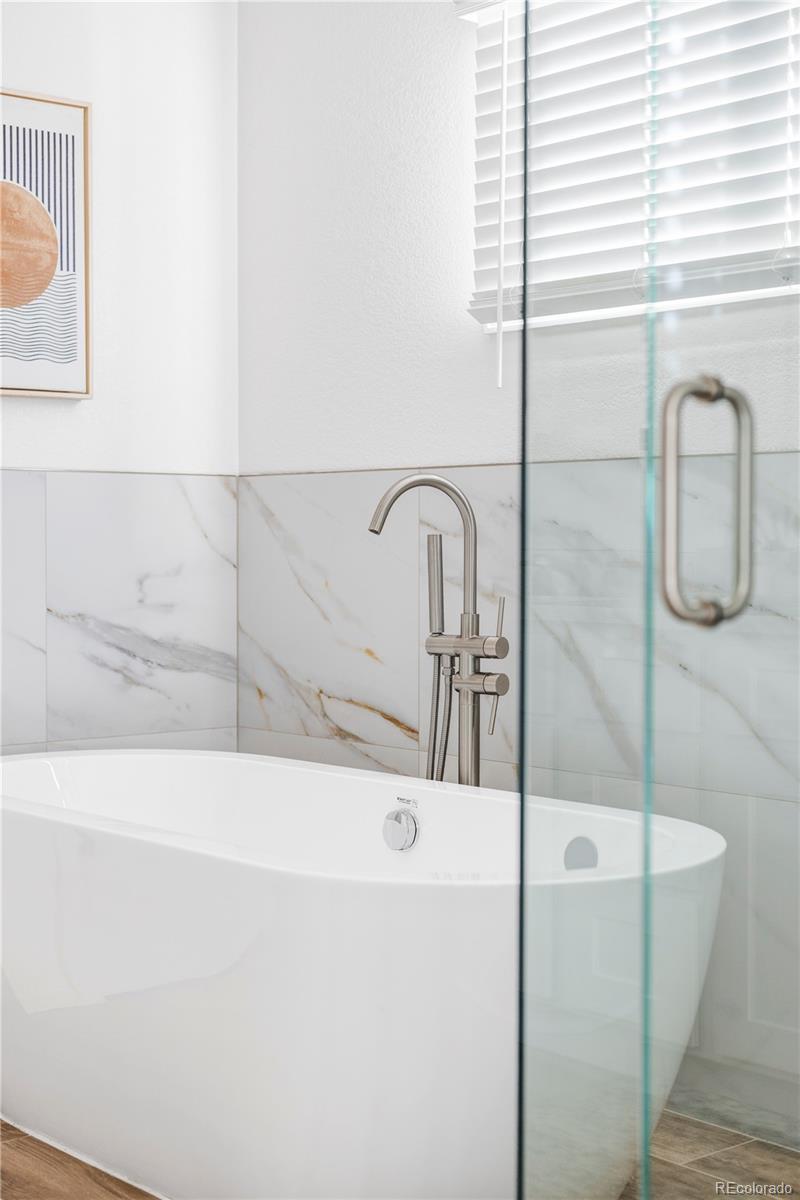 12829 Claude Place Thornton, CO 80241 - Photo 31 of 39 a bathroom with a bathtub and a sink