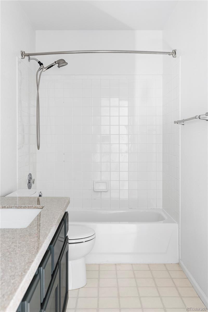 12829 Claude Place Thornton, CO 80241 - Photo 35 of 39 a bathroom with a granite countertop bathtub shower sink vanity and toilet