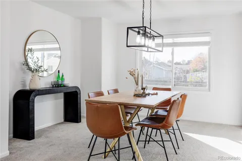 a dining room with furniture a chandelier and wooden floor