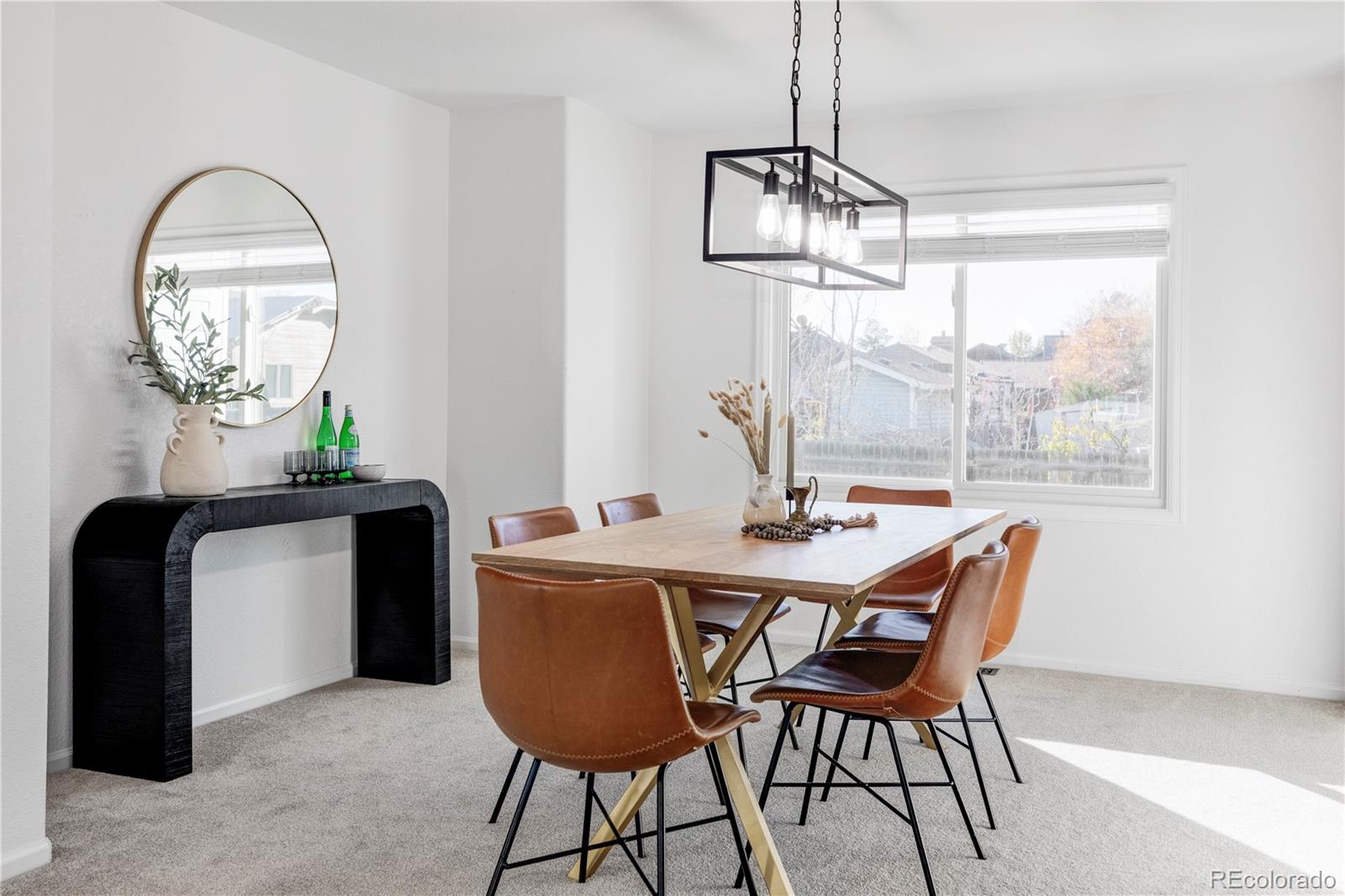 12829 Claude Place Thornton, CO 80241 - Photo 9 of 39 a dining room with furniture a chandelier and wooden floor