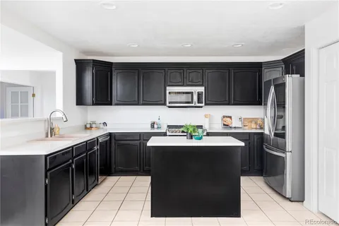 a kitchen with a sink a stove top oven and wooden cabinets