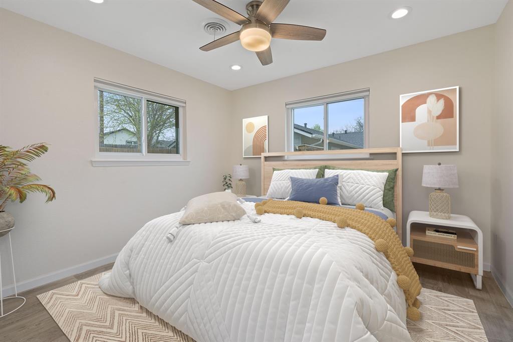 5211 Halmark Drive Austin, TX 78723 - Photo 20 of 27 Well-lit bedroom showcasing hardwood flooring and a stylish ceiling fan with integrated lighting.