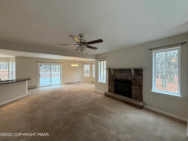 a view of empty room with windows and fireplace