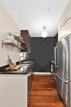 a kitchen with stainless steel appliances granite countertop a refrigerator a sink and a stove