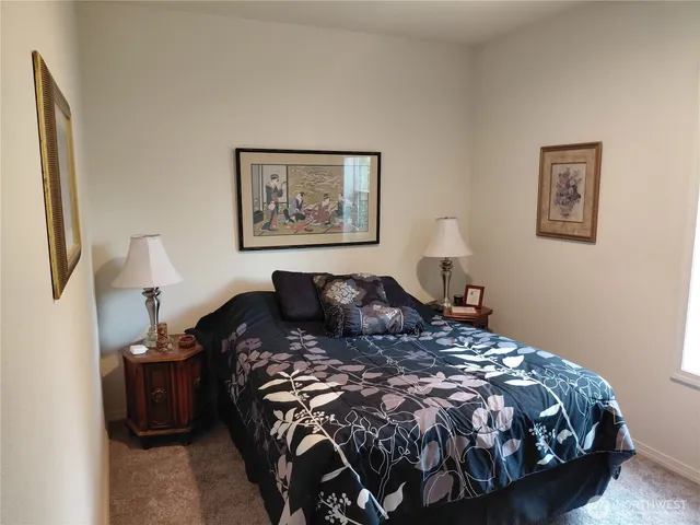 a bed sitting in a bedroom next to a lamp