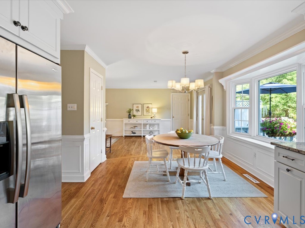 5309 Rock Harbour Road Midlothian, VA 23112 - Photo 15 of 47 a dining room with furniture a chandelier and wooden floor