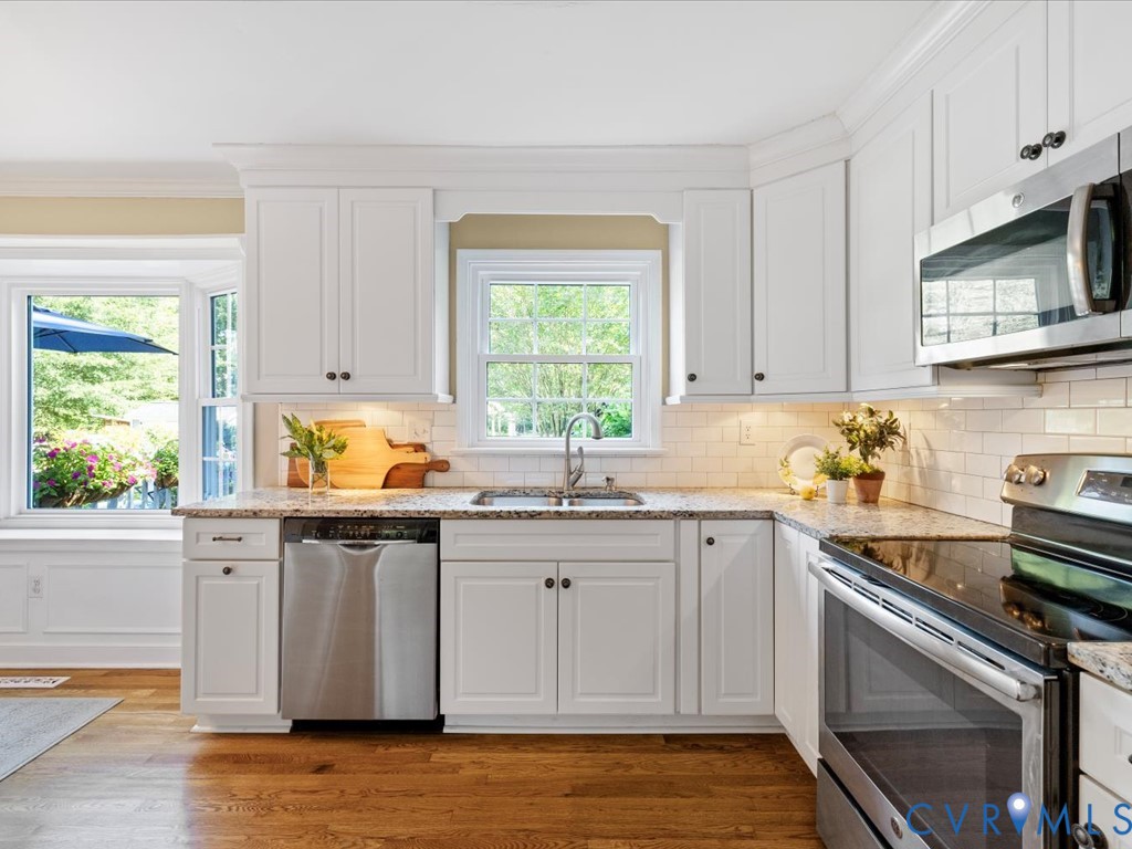 5309 Rock Harbour Road Midlothian, VA 23112 - Photo 16 of 47 a kitchen with stainless steel appliances white cabinets a sink and a stove