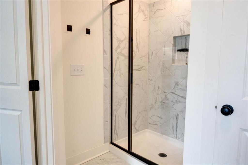 7621 Avalon Boulevard Fairburn, GA 30213 - Photo 18 of 25 a bathroom with a glass shower door