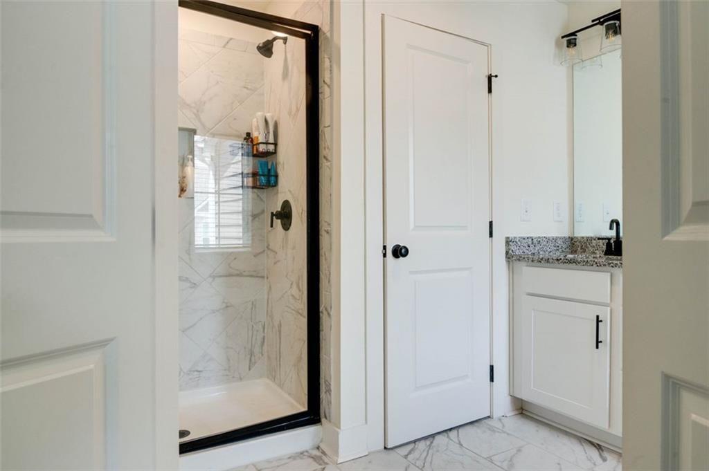 7621 Avalon Boulevard Fairburn, GA 30213 - Photo 20 of 25 a bathroom with a granite countertop mirror and a shower