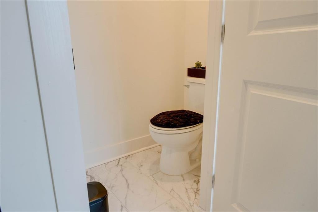 7621 Avalon Boulevard Fairburn, GA 30213 - Photo 21 of 25 a bathroom with a toilet and a shower