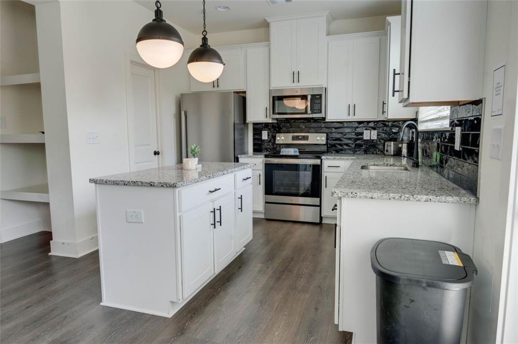 7621 Avalon Boulevard Fairburn, GA 30213 - Photo 8 of 25 a kitchen with sink a microwave a stove and refrigerator