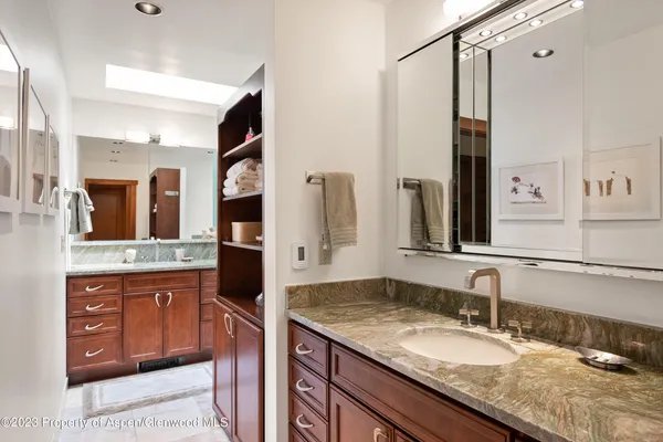 a bathroom with a granite countertop double vanity sink and a mirror