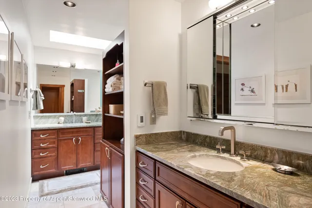 a bathroom with a granite countertop double vanity sink and a mirror