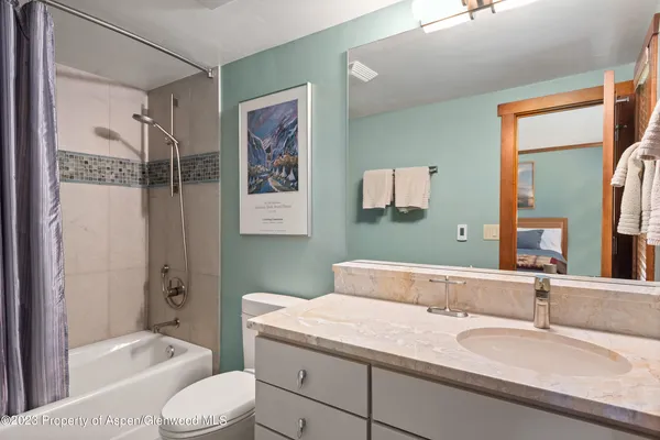 a bathroom with a granite countertop sink toilet and shower