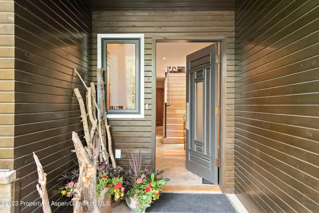 a view of a door of the house with a potted plant
