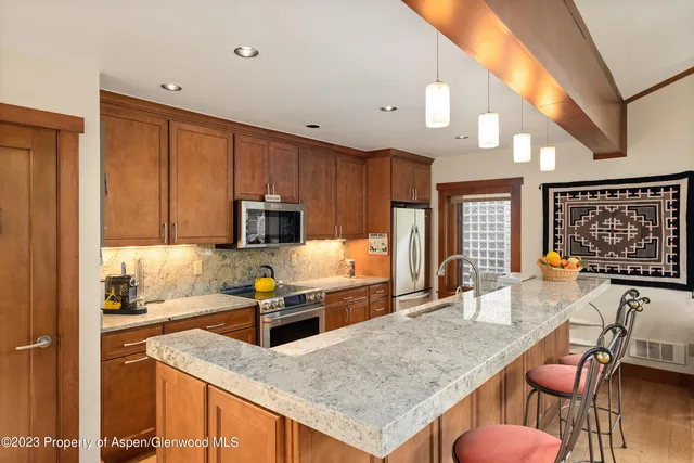 a kitchen with stainless steel appliances granite countertop a stove top oven a sink dishwasher and cabinets with wooden floor