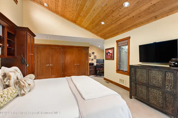 a bedroom with a bed and a flat screen tv