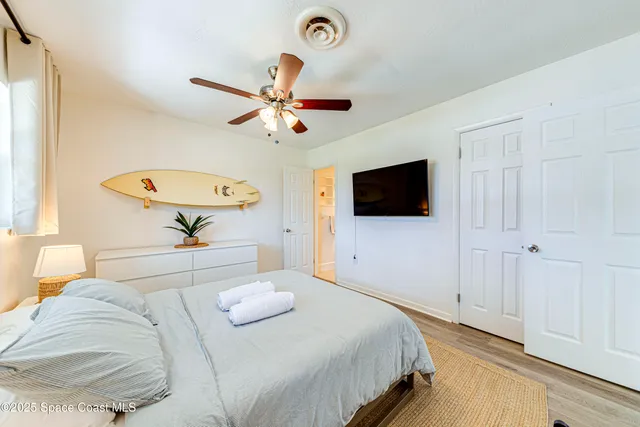 a bedroom with a large bed and a flat screen tv