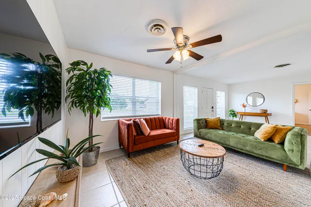 a living room with furniture and a potted plant